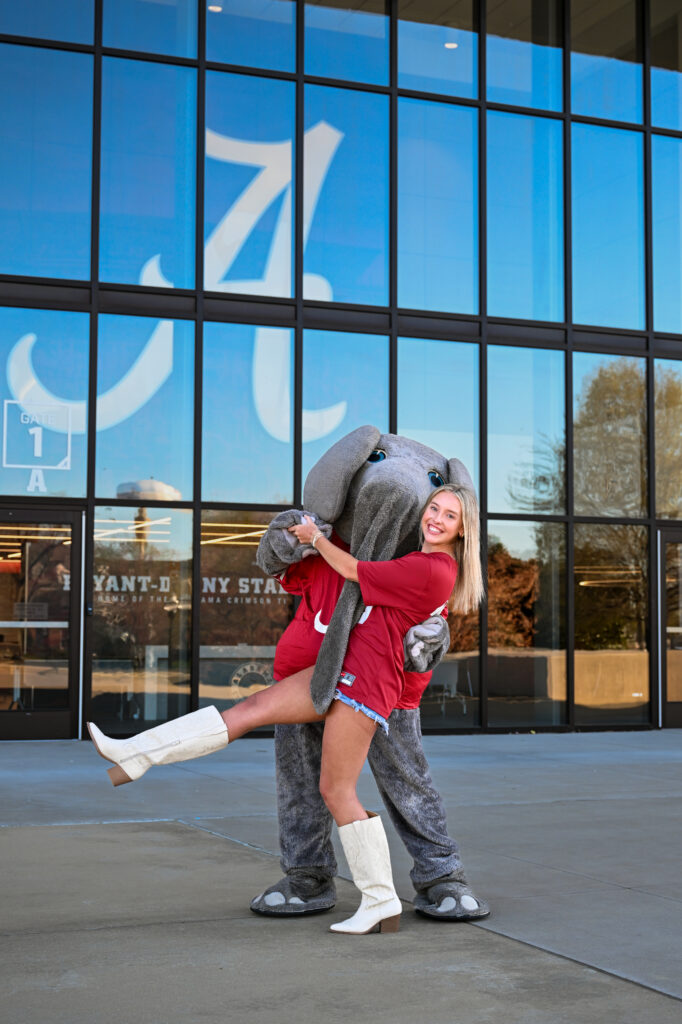 Alabama mascot Big AL dances with Alabama graduate at her grad photoshoot with Chris landau Photography. They are dancing in front of Bryant Denny stadium script A. Alabama grad photographer
