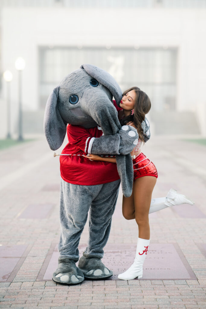 Alabama mascot Big AL hugs an Alabama crimsonette at her graduation photoshoot with Chris Landau Photography Alabama grad photographer.